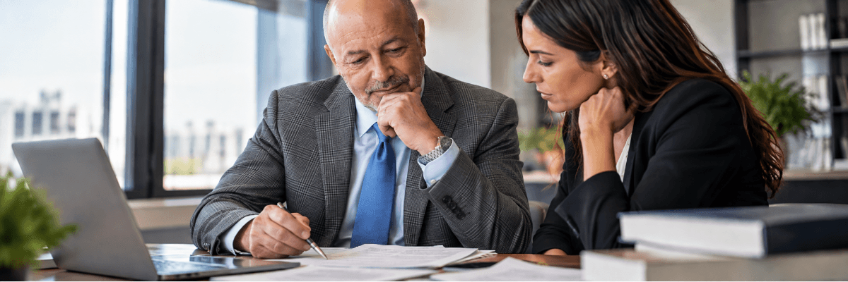 Un avvocato ed una professionista esaminano un contratto di collaborazione in ufficio.